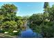 Community pond with fountain, lush tropical landscaping, and calm reflective water at 6450 Wild Oak Bay Blvd # 240, Bradenton, FL 34210