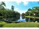 Scenic pond view with a fountain surrounded by lush greenery and mature trees at 6450 Wild Oak Bay Blvd # 240, Bradenton, FL 34210