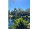 Scenic pond reflects the nearby building, framed by trees and lush greenery, creating a tranquil setting at 6450 Wild Oak Bay Blvd # 240, Bradenton, FL 34210