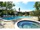 Community pool featuring a hot tub, lounge chairs and tropical landscaping at 6450 Wild Oak Bay Blvd # 240, Bradenton, FL 34210