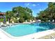Community pool with lounge chairs and lush landscaping under a bright blue sky at 6450 Wild Oak Bay Blvd # 240, Bradenton, FL 34210