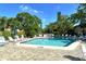 Community pool surrounded by lounge chairs and lush landscaping at 6450 Wild Oak Bay Blvd # 240, Bradenton, FL 34210