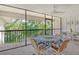 Screened-in porch with dining table, ceiling fan, and serene views of the community pond at 6450 Wild Oak Bay Blvd # 240, Bradenton, FL 34210