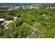 Aerial view showcases the property surrounded by lush trees, with ocean view in the distance at 6905 Arbor Oaks Ct, Bradenton, FL 34209