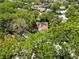 An aerial view reveals a home nestled among mature trees, surrounded by lush greenery at 6905 Arbor Oaks Ct, Bradenton, FL 34209
