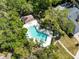 Aerial shot showcasing a beautiful backyard pool and outdoor area surrounded by lush trees at 6905 Arbor Oaks Ct, Bradenton, FL 34209