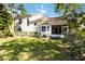 View of the home's backyard featuring a lawn, screened porch, and partial view of the rear exterior at 6905 Arbor Oaks Ct, Bradenton, FL 34209
