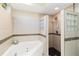 Bathroom featuring a corner soaking tub with jets and a step-in shower with glass block at 6905 Arbor Oaks Ct, Bradenton, FL 34209