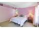 Cozy bedroom with a white quilt, two side tables with lamps and windows at 6905 Arbor Oaks Ct, Bradenton, FL 34209
