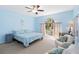 Bright bedroom features a ceiling fan, a large window, and a light blue comforter and walls at 6905 Arbor Oaks Ct, Bradenton, FL 34209