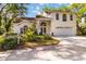 Charming two-story home featuring a manicured lawn, double-door entrance, and an attached two-car garage at 6905 Arbor Oaks Ct, Bradenton, FL 34209