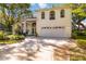 Charming two-story home featuring a manicured lawn, double-door entrance, and an attached two-car garage at 6905 Arbor Oaks Ct, Bradenton, FL 34209