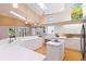 Bright kitchen featuring white cabinets, island cooktop, breakfast bar, and natural light from skylights and large windows at 6905 Arbor Oaks Ct, Bradenton, FL 34209