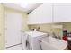 Functional laundry room with ample storage, sink, and modern washer and dryer at 6905 Arbor Oaks Ct, Bradenton, FL 34209