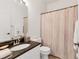 Neutral bathroom with a sink and vanity with granite countertop, a toilet, and a shower with a curtain at 6907 Stoneywalk Ct, Bradenton, FL 34203
