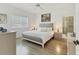 This airy bedroom includes wood floors, a ceiling fan, and a large bed with a light gray headboard at 6907 Stoneywalk Ct, Bradenton, FL 34203