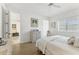 Cozy bedroom with wood floors, a large window, and a queen bed draped with white linens at 6907 Stoneywalk Ct, Bradenton, FL 34203