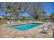 Community pool with brick paver deck, surrounded by lounge chairs, and mature landscaping at 6907 Stoneywalk Ct, Bradenton, FL 34203