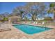 Community pool with brick paver deck, surrounded by lounge chairs, mature trees and covered picnic area at 6907 Stoneywalk Ct, Bradenton, FL 34203