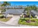 Well-maintained single-story home featuring a lush green lawn, manicured shrubs, and a two-car garage at 6907 Stoneywalk Ct, Bradenton, FL 34203