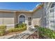 Charming front entrance with mulch and green shrubs with the home's exterior stucco at 6907 Stoneywalk Ct, Bradenton, FL 34203