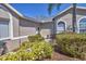 Well-maintained front yard with green shrubs, mulch, and beige stucco siding at 6907 Stoneywalk Ct, Bradenton, FL 34203