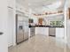 The kitchen features stainless steel appliances, white cabinets, dark granite countertops, and tile floors at 6907 Stoneywalk Ct, Bradenton, FL 34203
