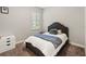 Cozy bedroom featuring a comfortable bed with stylish blue accents and a window with plantation shutters at 6913 Neopolitan Ct, Apollo Beach, FL 33572