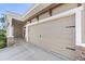 Attached two car garage with carriage style doors with decorative hardware and stone accents at 6913 Neopolitan Ct, Apollo Beach, FL 33572