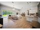 Open-concept living room featuring wood floors, modern lighting, and access to outdoor space at 6913 Neopolitan Ct, Apollo Beach, FL 33572