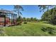 Landscaped backyard featuring a pond and screened-in patio with comfortable seating at 7004 Old Tabby Cir, Lakewood Ranch, FL 34202