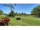Scenic backyard featuring a pond, lush landscaping, and open green space at 7004 Old Tabby Cir, Lakewood Ranch, FL 34202