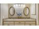 Bathroom vanity features dual sinks, granite countertops, and decorative oval mirrors at 7004 Old Tabby Cir, Lakewood Ranch, FL 34202
