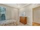 Bright bedroom with floral bedding, wood dresser, and neutral carpeting at 7004 Old Tabby Cir, Lakewood Ranch, FL 34202