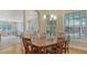 Bright dining room featuring wood floors, elegant lighting, and large windows offering a scenic outdoor view at 7004 Old Tabby Cir, Lakewood Ranch, FL 34202