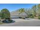 A three-car garage home boasting a well manicured lawn and mature trees providing shade at 7004 Old Tabby Cir, Lakewood Ranch, FL 34202
