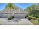 Charming home showcasing a three-car garage with attractive landscaping and a well-maintained driveway at 7004 Old Tabby Cir, Lakewood Ranch, FL 34202