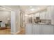 White kitchen features granite countertops, stainless appliances, and hardwood floors at 7004 Old Tabby Cir, Lakewood Ranch, FL 34202
