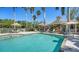 Community pool with clear blue water, lounge chairs, umbrellas, and a beautiful pool house at 7004 Old Tabby Cir, Lakewood Ranch, FL 34202