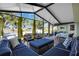 Bright sunroom features tiled flooring, ample seating, and views of the backyard at 717 Guild Dr, Venice, FL 34285