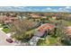 Stunning aerial view of a home with a red tile roof, lush landscaping, and a scenic lake backdrop at 730 Foggy Morn Ln, Bradenton, FL 34212