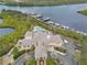 An aerial view shows the River Club, boat docks, swimming pool, and lush tropical landscaping at 730 Foggy Morn Ln, Bradenton, FL 34212