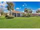 Well-manicured backyard with green grass, tropical plants, and a screened-in lanai at 730 Foggy Morn Ln, Bradenton, FL 34212