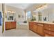 Primary bathroom with dual sinks, framed mirrors, tub, cabinets, and tile flooring at 730 Foggy Morn Ln, Bradenton, FL 34212