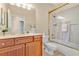 Well-lit bathroom features a wood vanity, framed mirror, and a shower-over-tub combo at 730 Foggy Morn Ln, Bradenton, FL 34212