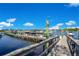 Community boat dock featuring multiple boat slips, power pedestals, and a wooden boardwalk on a sunny day at 730 Foggy Morn Ln, Bradenton, FL 34212