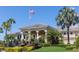 The building's facade is surrounded by lush landscaping, palm trees, and a manicured lawn under a bright, clear sky at 730 Foggy Morn Ln, Bradenton, FL 34212