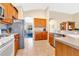 Spacious kitchen featuring wood cabinets, modern appliances, and a breakfast bar overlooking the living area at 730 Foggy Morn Ln, Bradenton, FL 34212