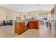 Open kitchen featuring wood cabinets, stainless steel appliances, breakfast bar, and a view into the adjacent living room at 730 Foggy Morn Ln, Bradenton, FL 34212