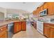 Well-lit kitchen featuring wood cabinets, modern appliances, and a breakfast bar overlooking the living area at 730 Foggy Morn Ln, Bradenton, FL 34212